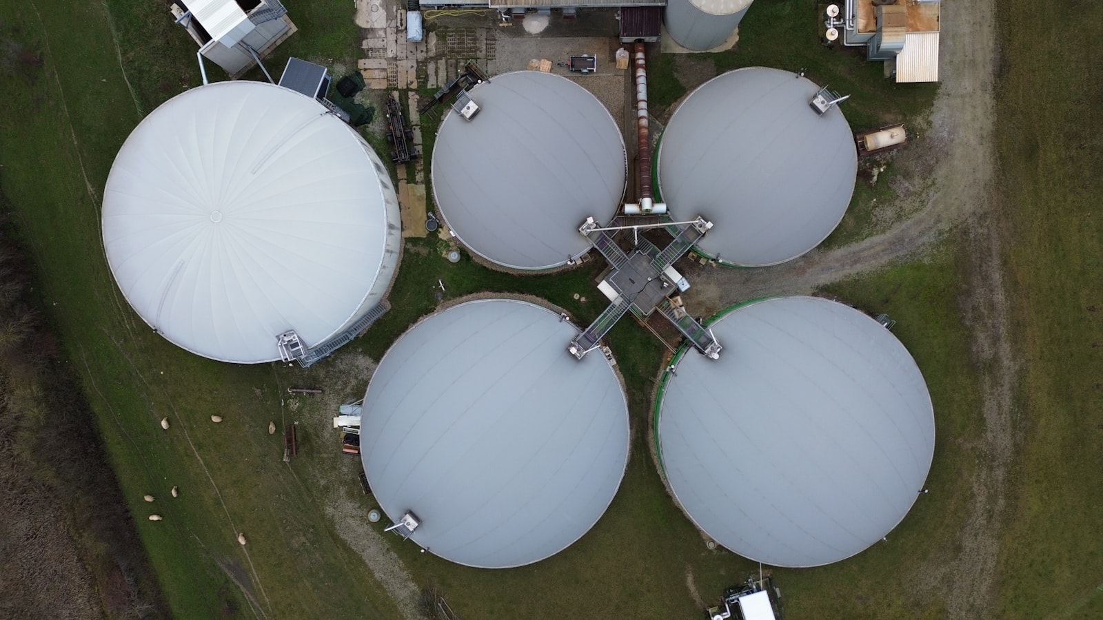 Biogas plant tanks in a green field